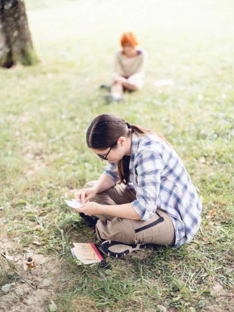 Très concentrées sur des éléments trouvés dans la nature, deux psychanalystes sont assises dans une clairière à quelques mètres l’une de l’autre et pratiquent un exercice sur l’exploration des blocages.