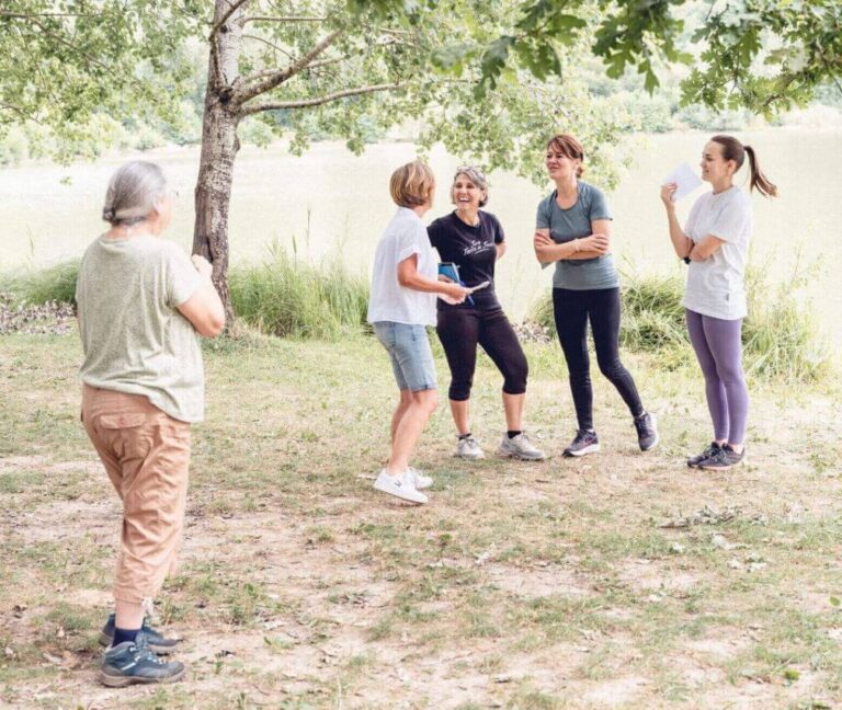 Tout près d’un lac, la formatrice et ses élèves interagissent ensemble et avec enthousiasme.