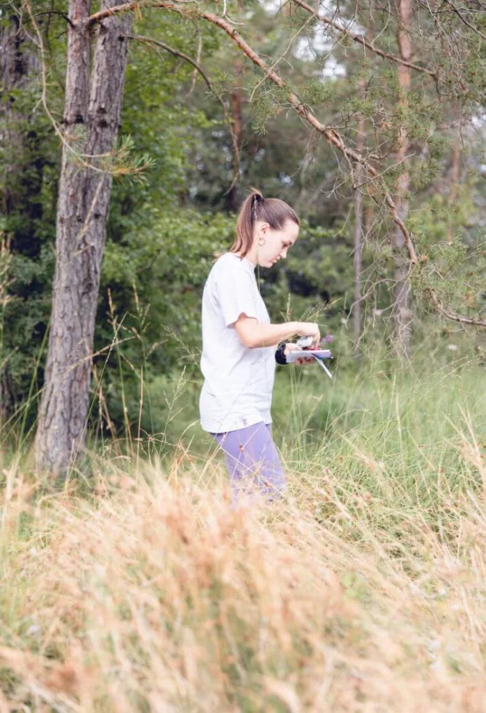Dans un champ avec des herbes hautes, une naturopathe expérimente un exercice pratique en marchant seule et doucement dans la nature.