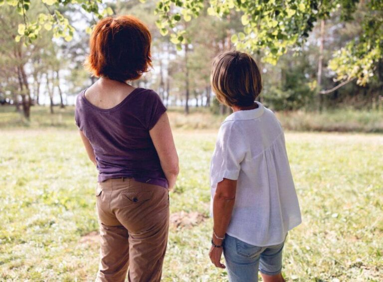 Une psychologue et sa patiente sont en train de regarder la nature en étant côte à côte durant une séance individuelle en plein cœur du Jura.