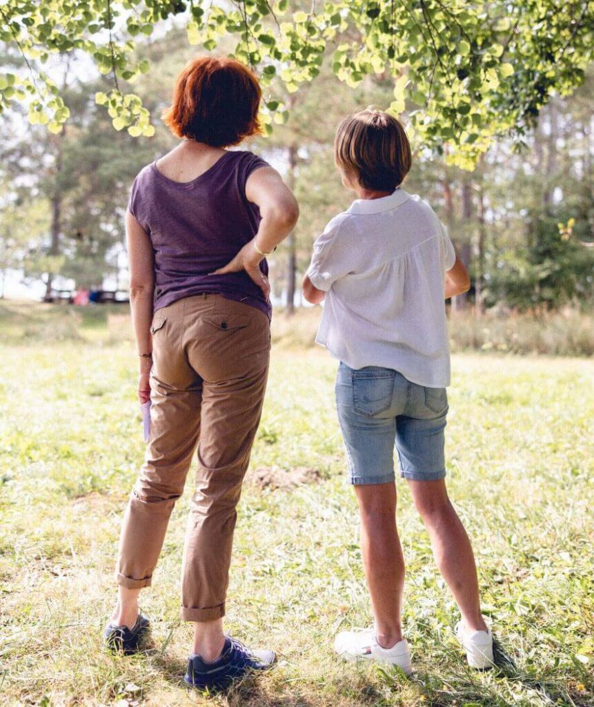 Au cœur d’une clairière située dans le Jura, une patiente et une psychologue sont côte à côte et observent la nature qui sert d’intermédiaire.